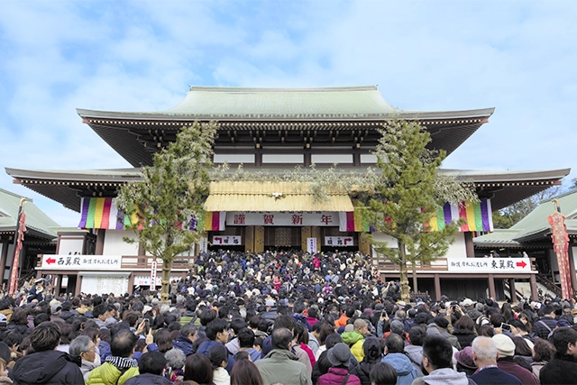 大本堂で多くの人々が初詣で賑わう様子