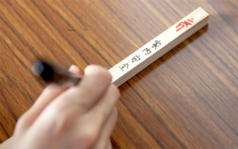 護摩木にお願い事を書く様子