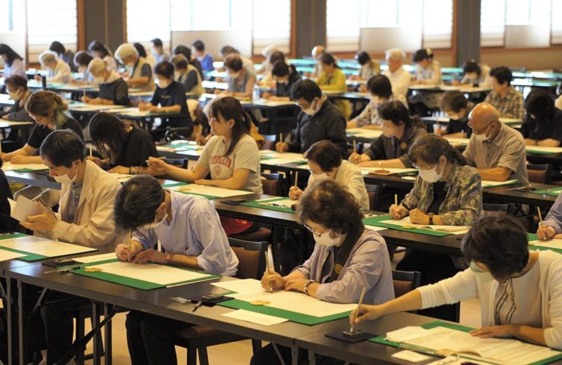 多くの人が精神を集中して写経を行う様子
